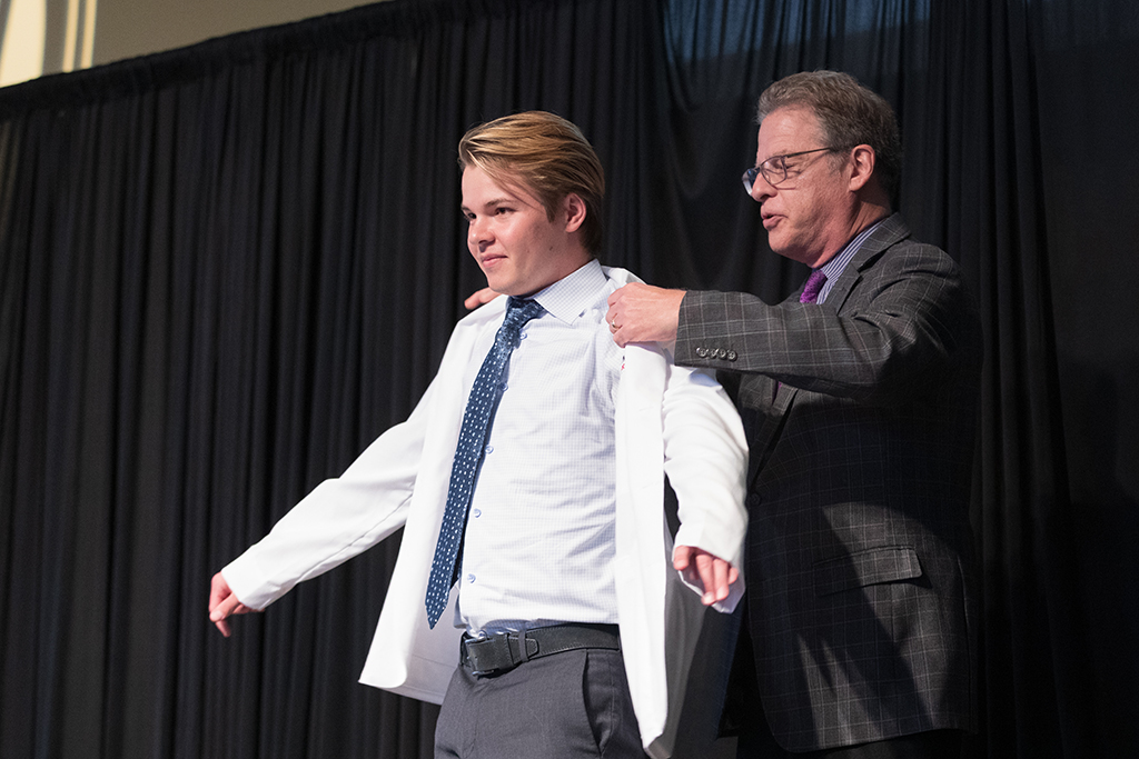 A student receives a white coat during the 2022 White Coat Ceremony.