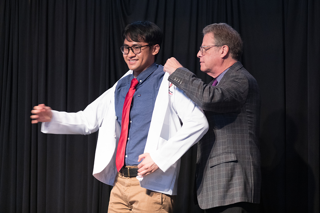 A student receives a white coat during the 2022 White Coat Ceremony.