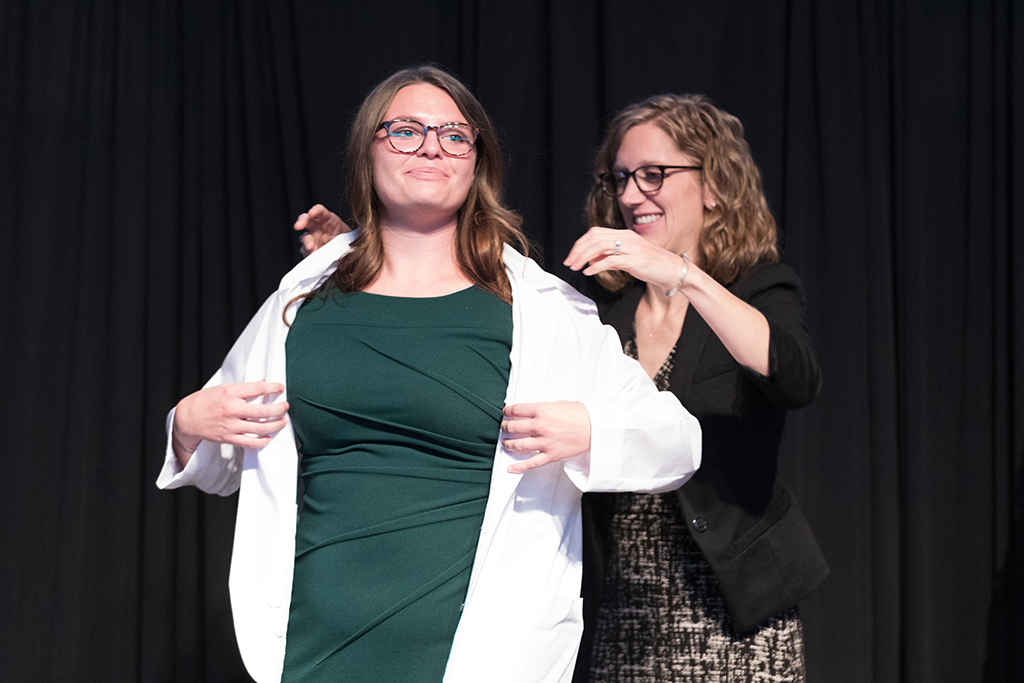 A student receives a white coat during the 2022 White Coat Ceremony.