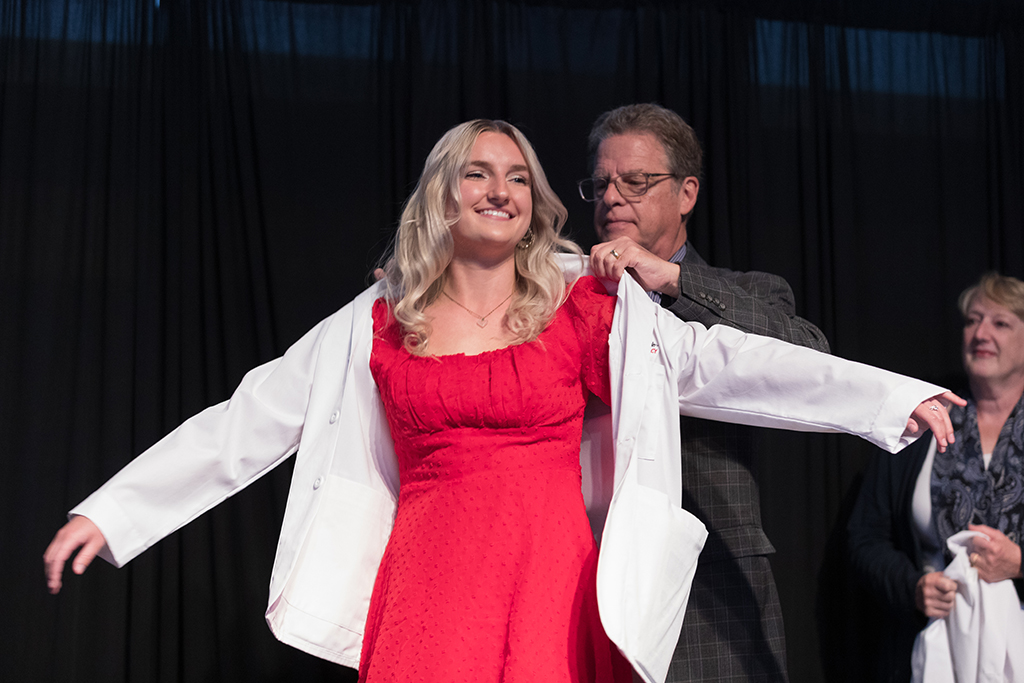 A student receives a white coat during the 2022 White Coat Ceremony.