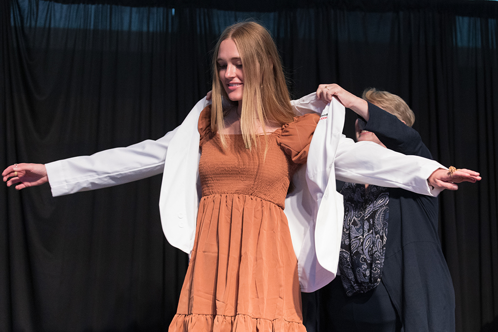 A student receives a white coat during the 2022 White Coat Ceremony.