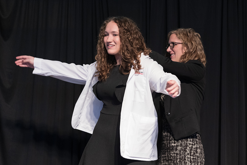 A student receives a white coat during the 2022 White Coat Ceremony.