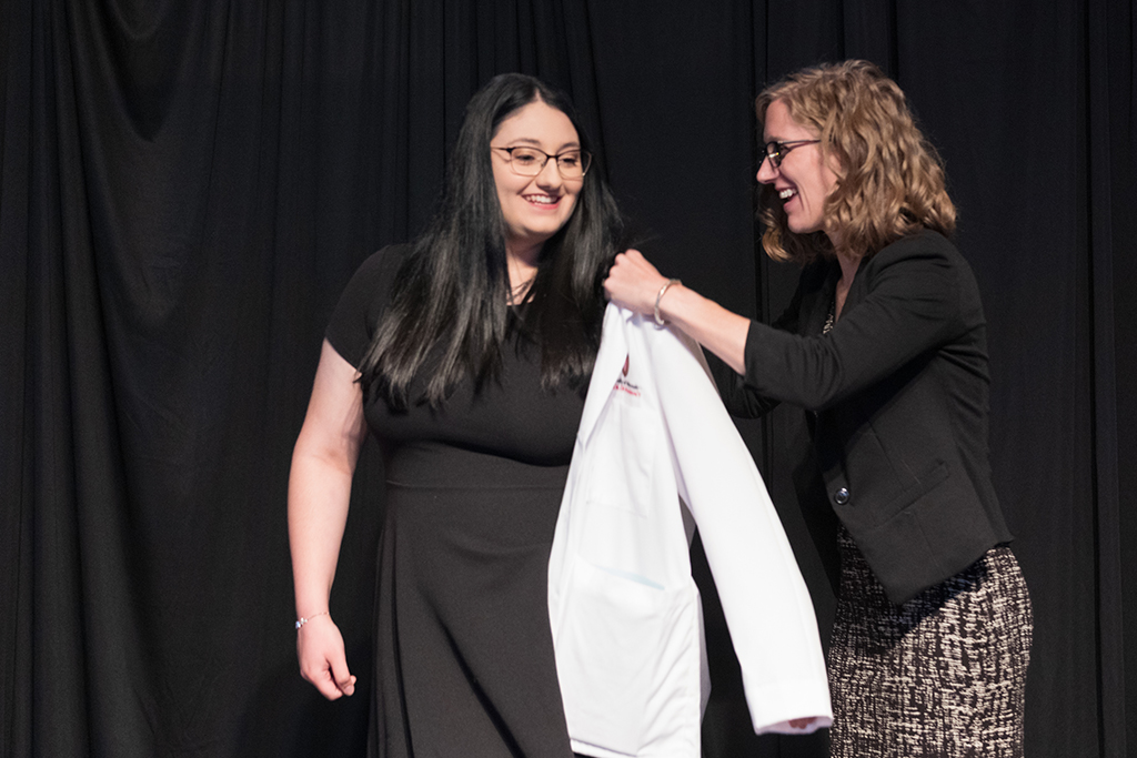 A student receives a white coat during the 2022 White Coat Ceremony.