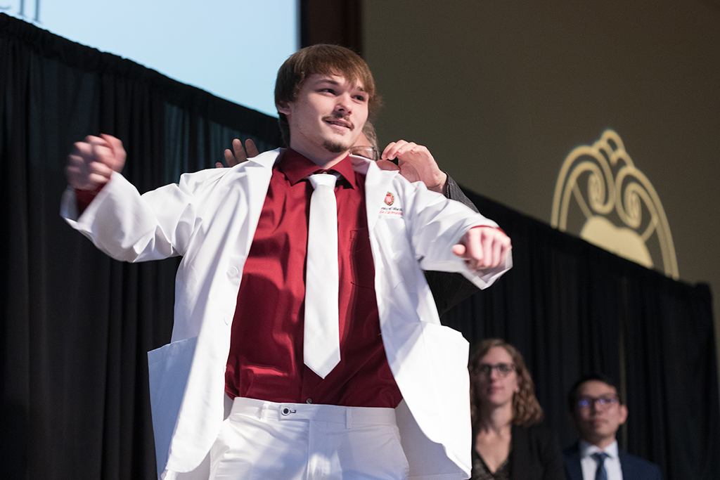 A student receives a white coat during the 2022 White Coat Ceremony.