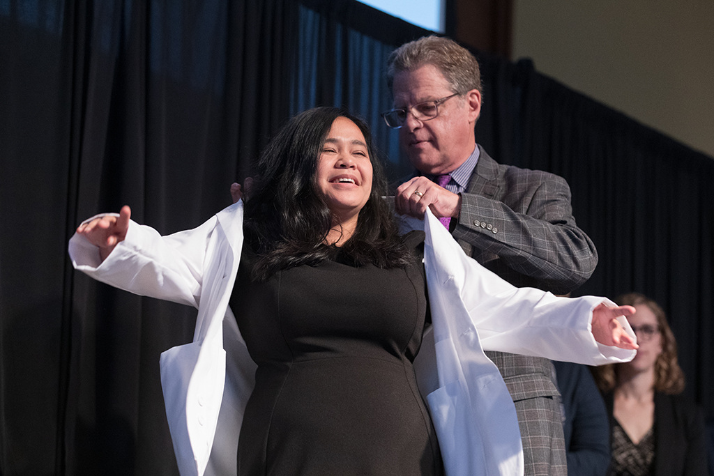 A student receives a white coat during the 2022 White Coat Ceremony.