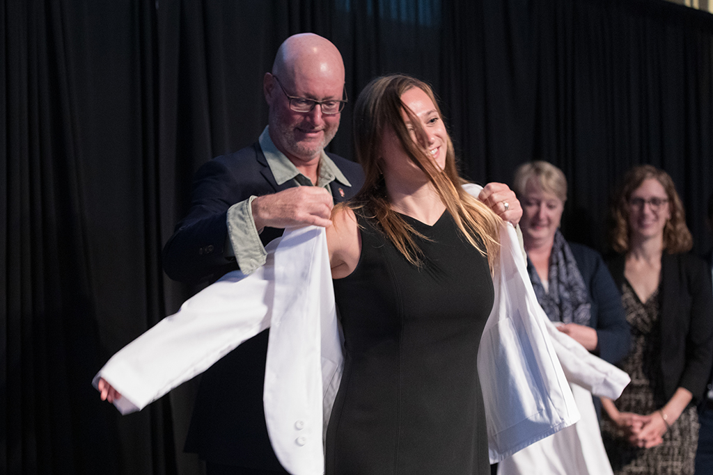 A student receives a white coat during the 2022 White Coat Ceremony.