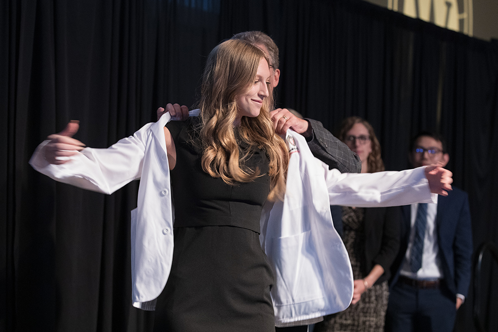 A student receives a white coat during the 2022 White Coat Ceremony.