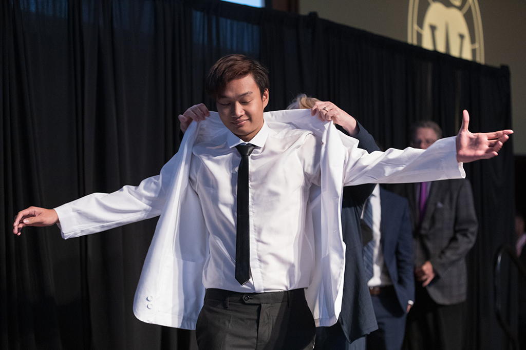 A student receives a white coat during the 2022 White Coat Ceremony.