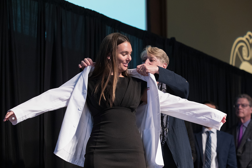 A student receives a white coat during the 2022 White Coat Ceremony.