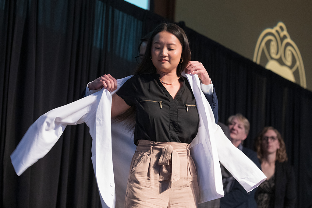 A student receives a white coat during the 2022 White Coat Ceremony.