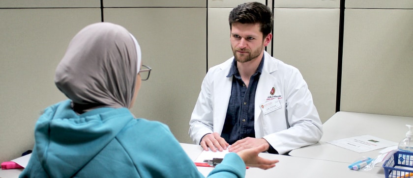 A pharmacy student meets with a patient to talk through a medication regimen during Ramadan