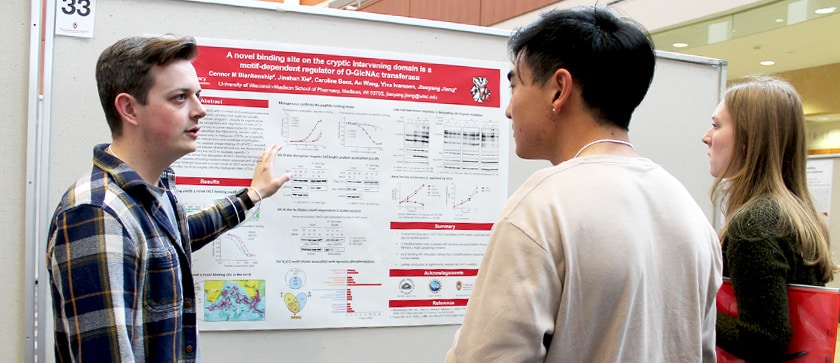 A Pharmsci graduate student talks about his research with a professor at a poster session