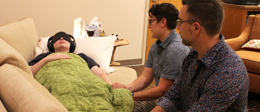Two supporters work with a patient during a psychotherapeutic session with psilocybin