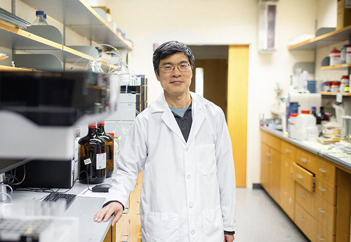 Pharmaceutical Sciences professor Weiping Tang stands at his lab bench | Photo by Sharon Vanorny